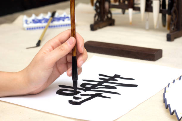 Traditional Chinese calligraphy Master writing a character translation means longevity. Asian art equipment and tools