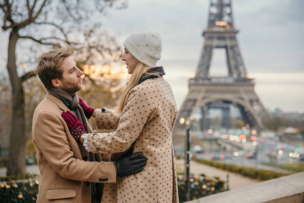 istock Couple hugging an standing close to each other with tree and Eiffel Tower, Paris, in the background 1372128169