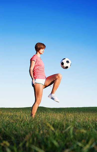 Jovem mulher jogar futebol - fotografia de stock