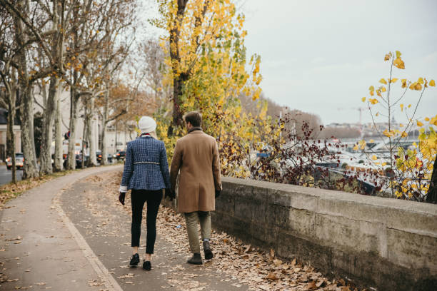 istock Couple with winter clothes holding hands while taking a walk at Seine River in Paris, rear view 1372128708