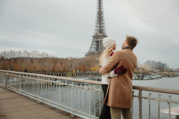 istock Romantic couple hugging each other closely while standing on a bridge at Seine River with Eiffel tower, Paris, in background 1372128711