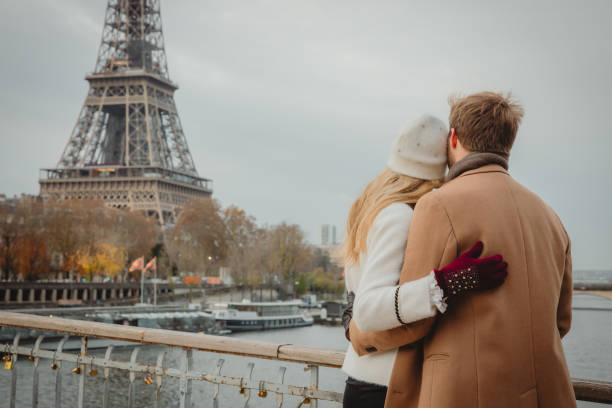 istock Couple hugging while standing at Seine River looking at Eiffel Tower, Paris, rear view 1372128902