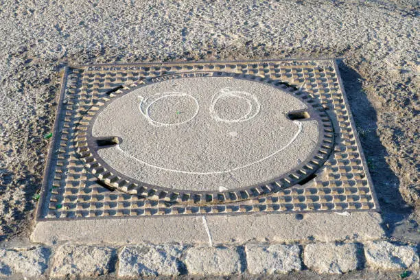 smiling smiley painted on manhole cover