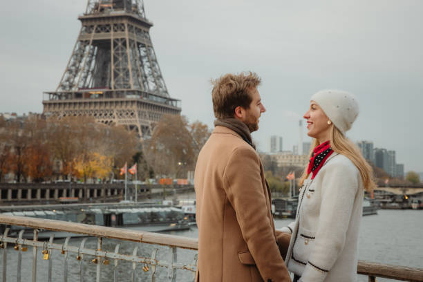 istock Romantic couple flirts while standing on a bridge at Seine River in front of Eiffel tower, Paris 1372129200