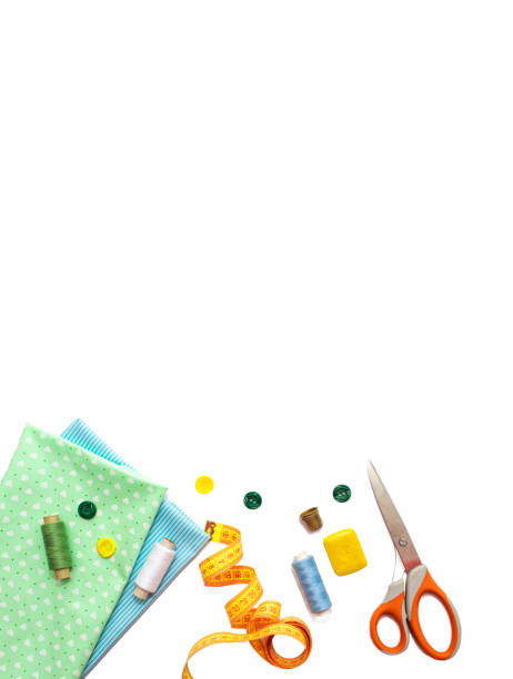 istock Sewing accessories, blue and green fabric on white background. Threads, needles, fabric, buttons and sewing centimeter. 1372130054