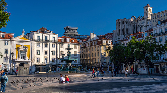 July 7, 2021.  Praça Dom Pedro IV, Rossio, Baixa, Lisbon, Portugal.\n\nView of Praça Dom Pedro IV, also called Rossio, in downtown Lisboa. It is a popular meeting and gathering place for tourists and locals alike.\nThe ruins of the Convento do Carmo are a reminder of the fateful earthquake of 1755.