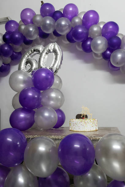 istock 60th birthday decorations with colorful balloons and white cakes from different angle 1372131014