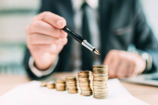 istock Investment return concept, businessman pointing to a coin stack at office desk 1372131124