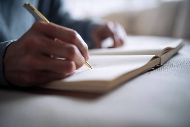 istock Cropped hand of man writing in notebook. 1372131315