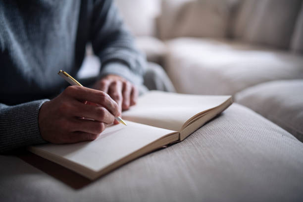 cropped hand of man writing in notebook. - poem imagens e fotografias de stock
