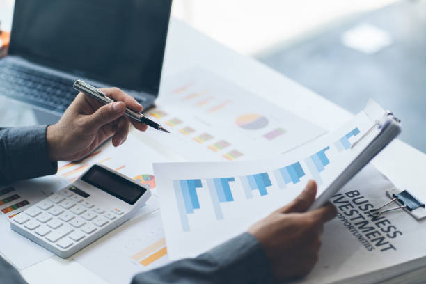 istock Business man working at office with laptop, tablet and graph data documents on his desk. 1372133081