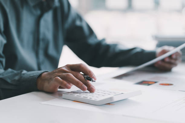 istock Business man working at office with laptop, tablet and graph data documents on his desk. 1372133284