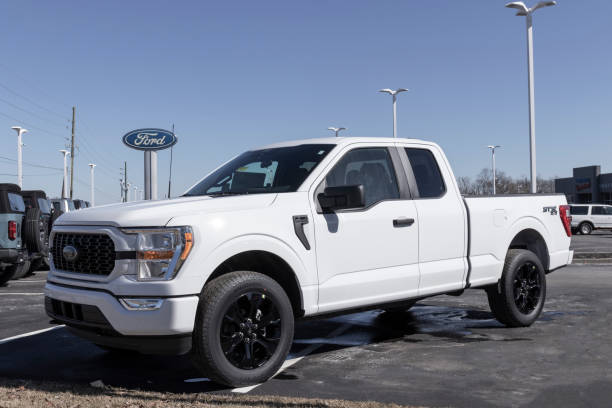 ford f-150 display at a dealership. the ford f150 is available in xl, xlt, lariat, king ranch, platinum, and limited models. - domestic car color image horizontal car imagens e fotografias de stock