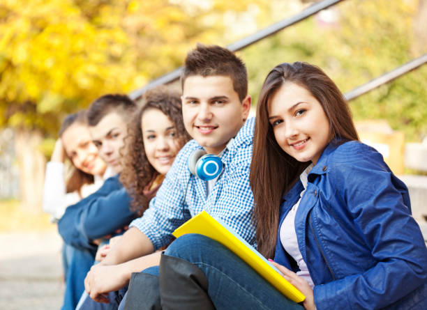 istock Group of college students sitting at campus 1372135461