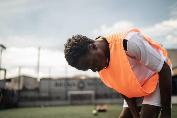 istock Player putting on sock on the soccer field 1372135940