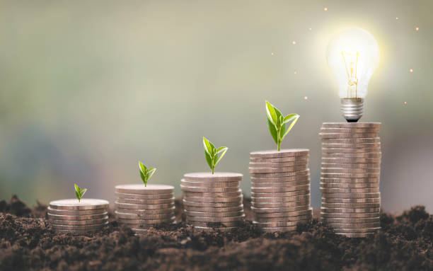 istock Coin stacked growing with light bulb. business idea, Energy saving concept 1372137135