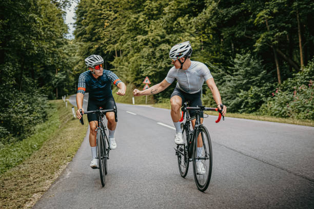 istock Cyclists making fist bump while riding bikes 1372137540