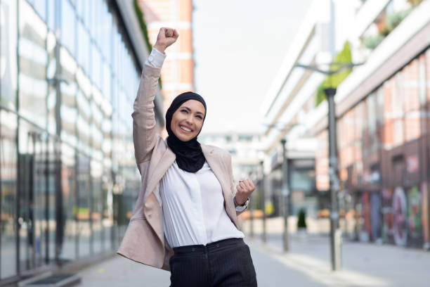Happy arabic woman holding hands up. Successful business arabic woman stock photo