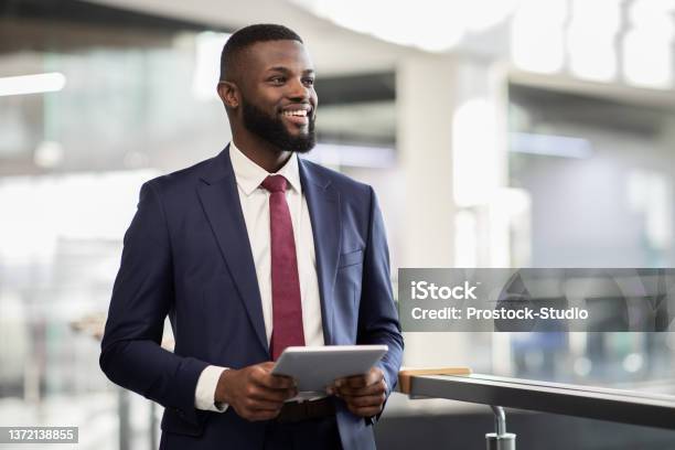 Cheerful Black Manager With Digital Tablet Walking By Office Stock Photo - Download Image Now