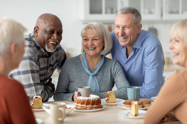 personas mayores alegres bebiendo té con pastel juntos - senior living communitiy fotografías e imágenes de stock