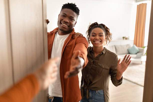 istock Hand Stretching For Handshake To African Couple Opening Doors Indoor 1372138902