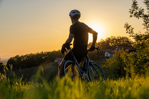 Cyclist relaxing on a bicycle and enjoying the view at sunset.