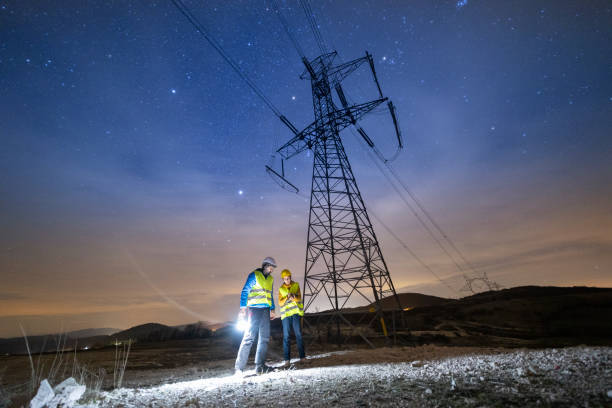 ingénieurs haute tension travaillant de nuit sur le terrain. travail d’équipe. - réseau électrique photos et images de collection