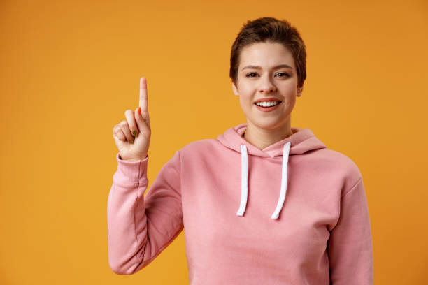 istock Young woman over isolated yellow background thinking an idea and pointing up 1372140192