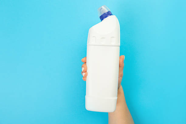 istock Housewife's hand holds a spray with cleaning agent on a blue background. Detergent for various surfaces in the kitchen, bathroom and other rooms. Close-up. Light pastel blue background. 1372140997
