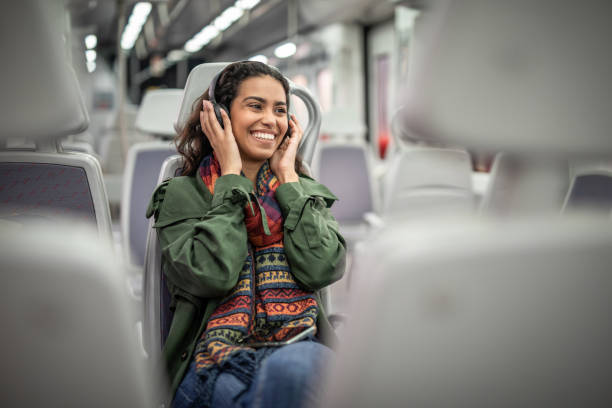 It is a great pleasure to travel with train and listening my favorite music One young woman, Young Brazilian woman with long curly hair travel in train and listening music on headphone. train interior stock pictures, royalty-free photos & images