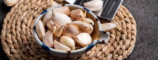 Close up of fresh garlic cloves on black table background.