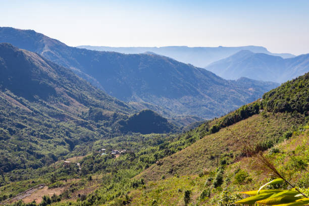 mountain range covered with dense green forests and bright blue sky at morning
