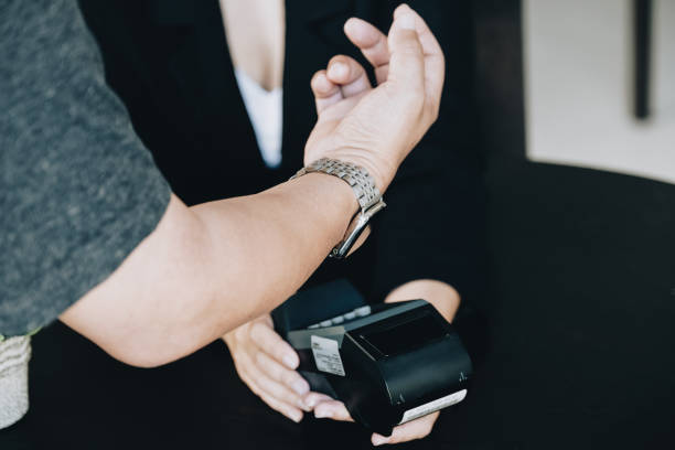 istock Payment security technology concept and service fees, Employees are holding electronic card machines for customers to use smartwatches to pay via paywave technology. 1372150521