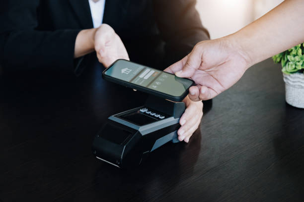 istock Payment security technology concept and service fees, Employees are holding electronic card machines for customers to use smartphone mobile to pay via paywave technology. 1372150654