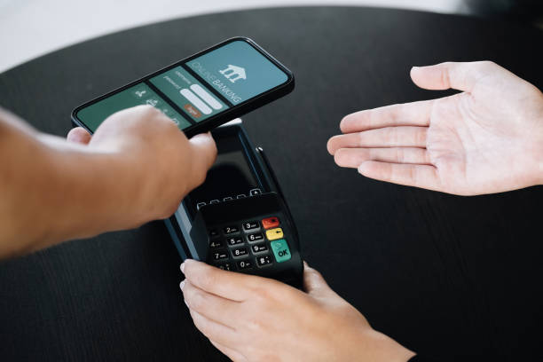istock Payment security technology concept and service fees, Employees are holding electronic card machines for customers to use smartphone mobile to pay via paywave technology. 1372150757
