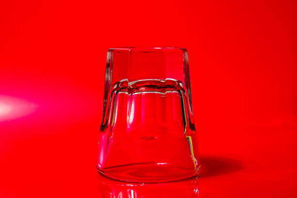 istock Shot glass upside down on a red background 1372150930