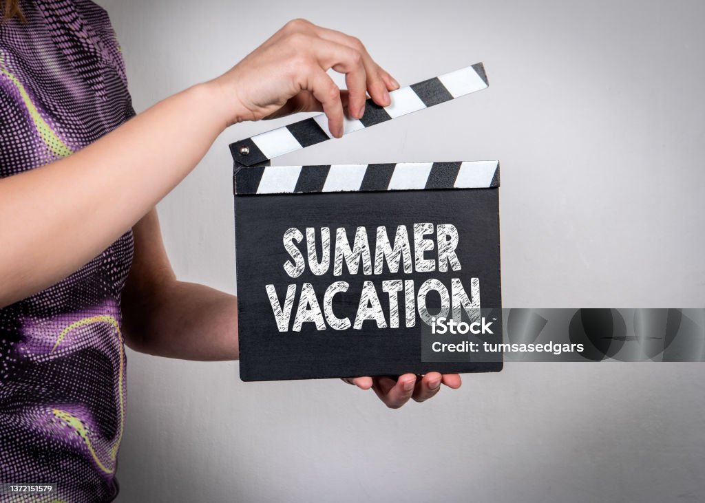 SUMMER VACATION. Female hands holding movie clapper SUMMER VACATION. Female hands holding movie clapper. Abstract Stock Photo