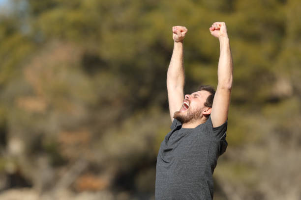 istock Excited man raising arms in nature 1372152394