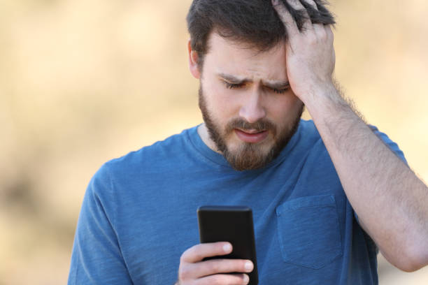 istock Worried man checking smartphone outdoors 1372152457