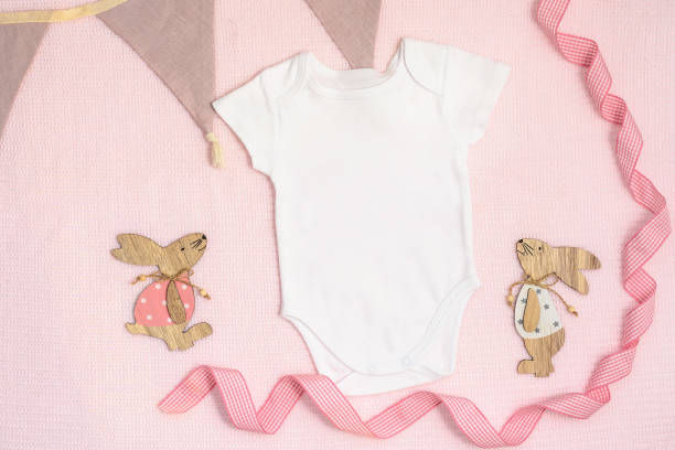 oster-mockup baby bodysuit auf rosa hintergrund. - onesie stock-fotos und bilder