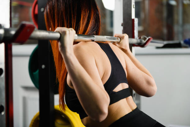 istock Woman back with weights in sport gym 1372155339