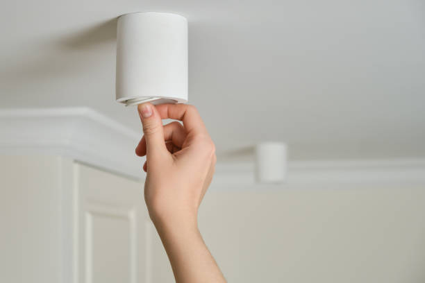 istock A woman changes a ceiling energy saving light bulb with LED light lamp in a home living room. Work at height self, diy 1372157476