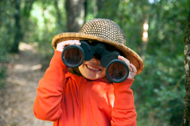 bambina felice che esplora attraverso il binocolo - osservare gli uccelli foto e immagini stock