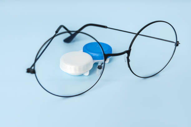 istock Round glasses for vision and a container with contact lenses on a blue background with a place for text 1372160475