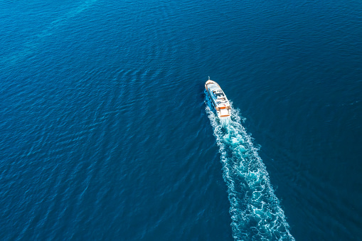 Yacht sails on Adriatic sea leaving white sea foam trace
