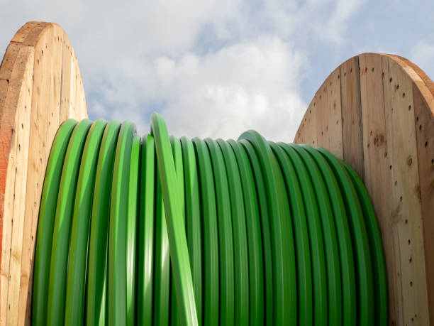 Wooden roller with green fiber optic cables for laying data cables at the construction site