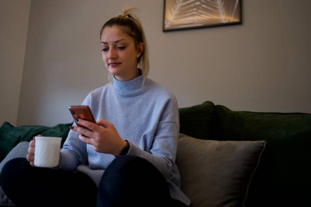 istock Young woman using phone at home 1372162216