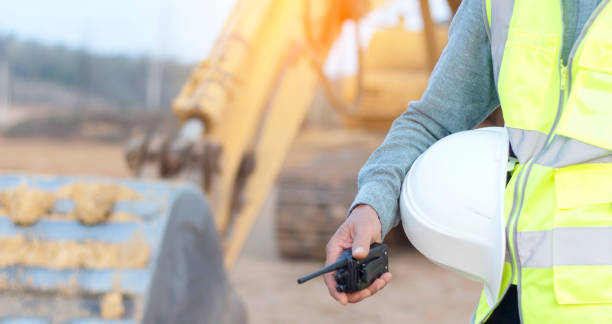 istock Engineer holding hard hat with walkie-talkie 1372162947