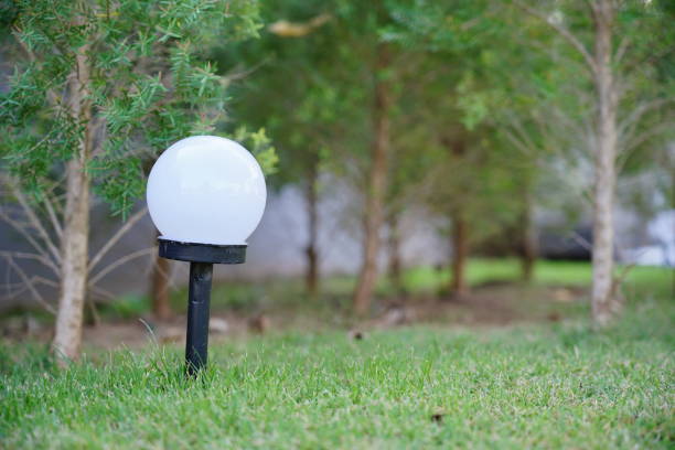 Illuminating garden lamp on green lawn