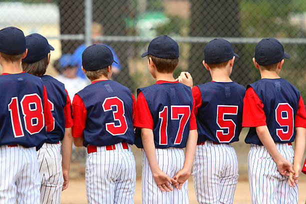 Youth League Teammates Little League players standing in line before a game. sports uniform photos stock pictures, royalty-free photos & images